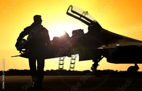 Military pilot on airfield walking away from the fighter jet
