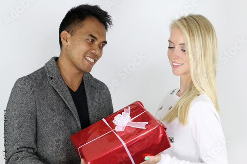 Jeune couple mixte s' offrant un cadeau