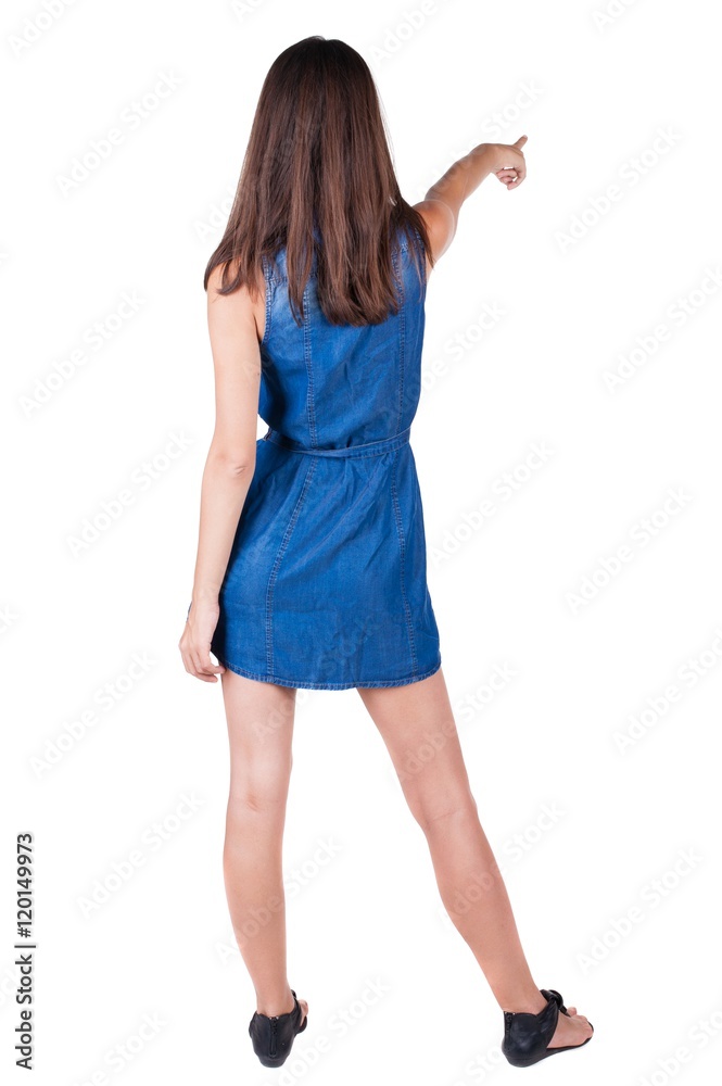 Fototapeta premium Back view of pointing woman. beautiful brunette girl in dress. Rear view people collection. backside view of person. Isolated over white background.