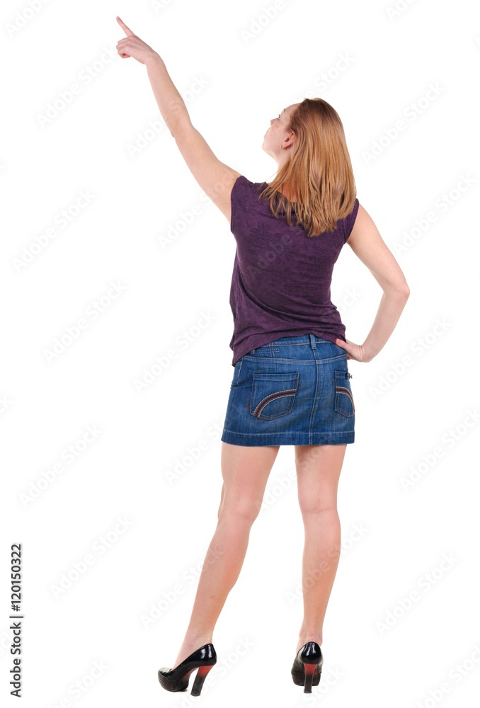Beautiful young woman in dress pointing at wall. Rear view. Isolated over white. Beautiful young woman in dress pointing at wall. Rear view. Isolated over white.