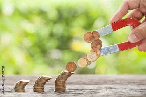 фотографія Concept of attracting investments. Horseshoe magnet attracts coi