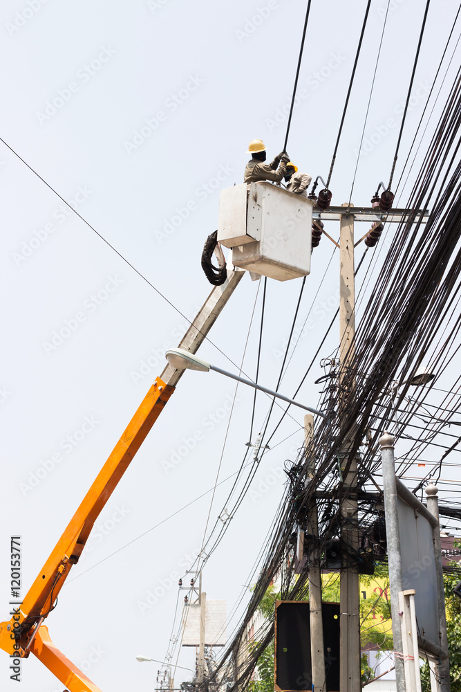 Electrician working repairing the power line on hydraulic platform Electrician working repairing the power line on hydraulic platform