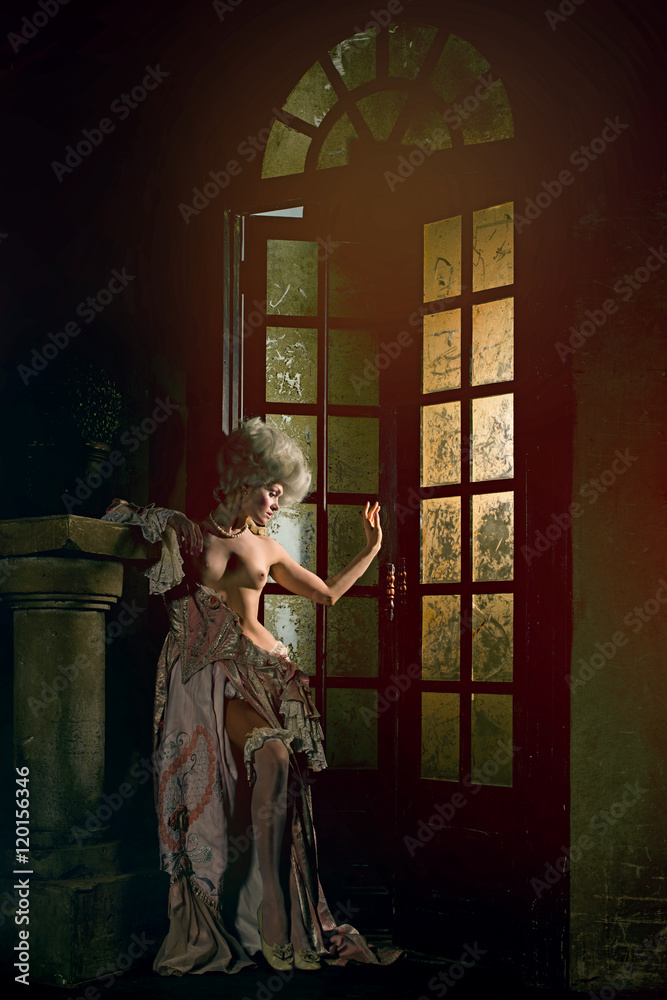 Naklejka premium Half-naked Victorian lady. Young woman in eighteenth century image posing in vintage interior