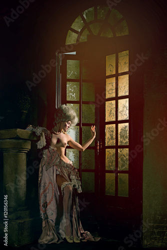 Half-naked Victorian lady. Young woman in eighteenth century image posing in vintage interior