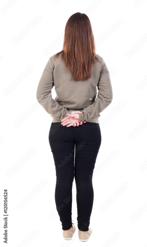 back view of standing young beautiful woman. girl watching. Rear view  people collection. backside view of person. Isolated over white background.  Girl standing with hands clasped behind his back. Stock Photo