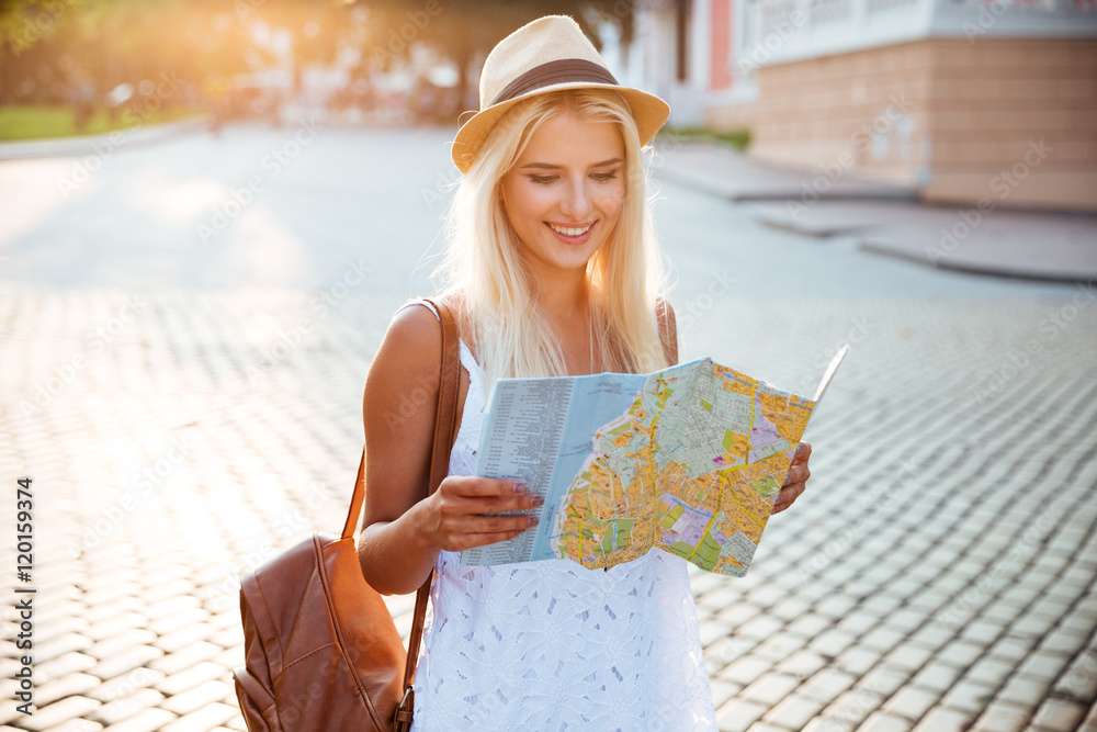 Happy tourist woman on vacation with map visiting city