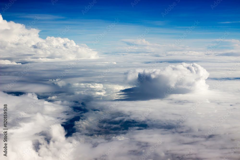 Fototapeta premium Cloud formations with blue sky seen from the plane