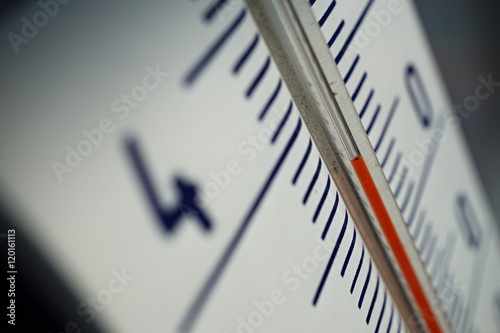 Macro detail of and old dusty outdoor thermometer in the retro design measuring very high temperature of thirty five degrees of Celsius as a symbol of summer and heat  photo