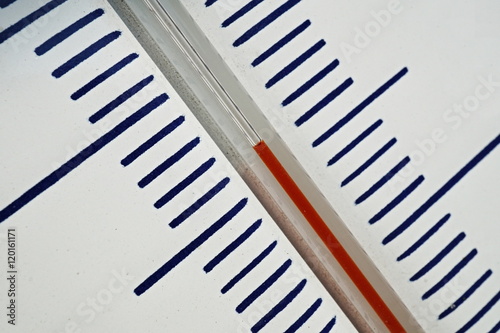 Macro detail of and old dusty outdoor thermometer in the retro design measuring very high temperature of thirty five degrees of Celsius as a symbol of summer and heat  photo