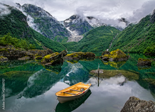 Boat on the lake on a background of mountains and glacier.Norway