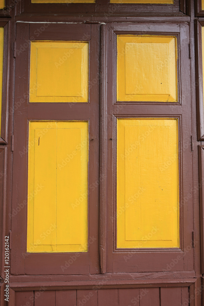 old wooden style windows with mustard yellow painted color