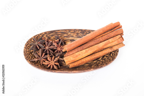 Cinnamon stick and star anise spice on wooden plate isolated on white background