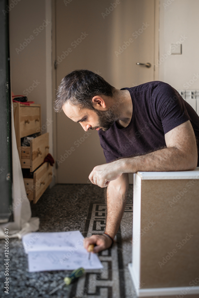 Bearded man with screwdriver reading circuit assembly Bearded man with screwdriver reading circuit assembly