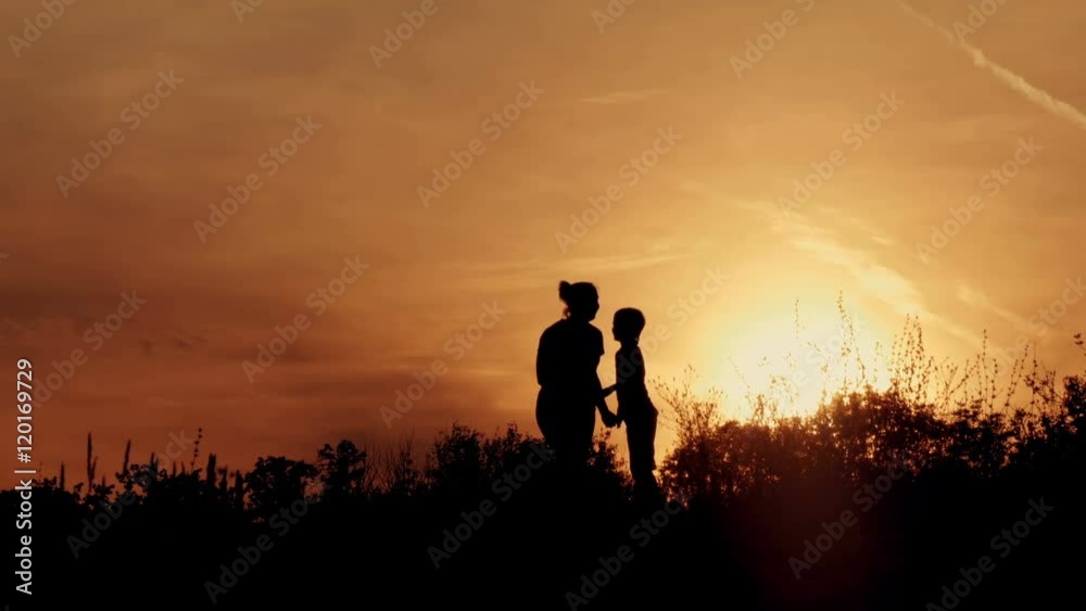 Silhouette, happy children with mother and father, family at sunset, summertime Silhouette, happy children with mother and father, family at sunset, summertime
