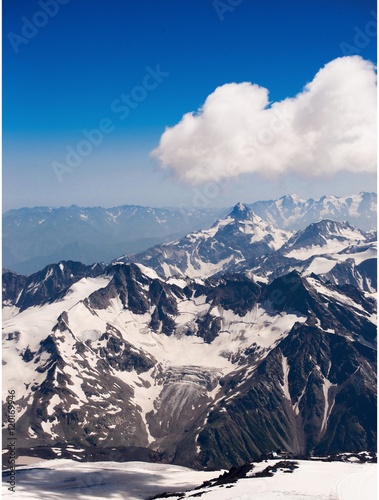Mountain landscape. snow-capped peaks of the mountains. The sharp peaks of the mountains in the snow, on a background of clouds. background for ski resort