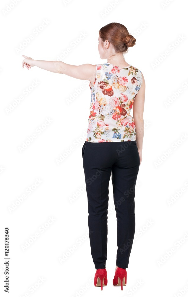 Back view of young redhead business woman pointing at wall. beautiful girl in dark suit. Rear view people collection. backside view of person. Isolated over white background. Back view of young redhead business woman pointing at wall. beautiful girl in dark suit. Rear view people collection. backside view of person. Isolated over white background.