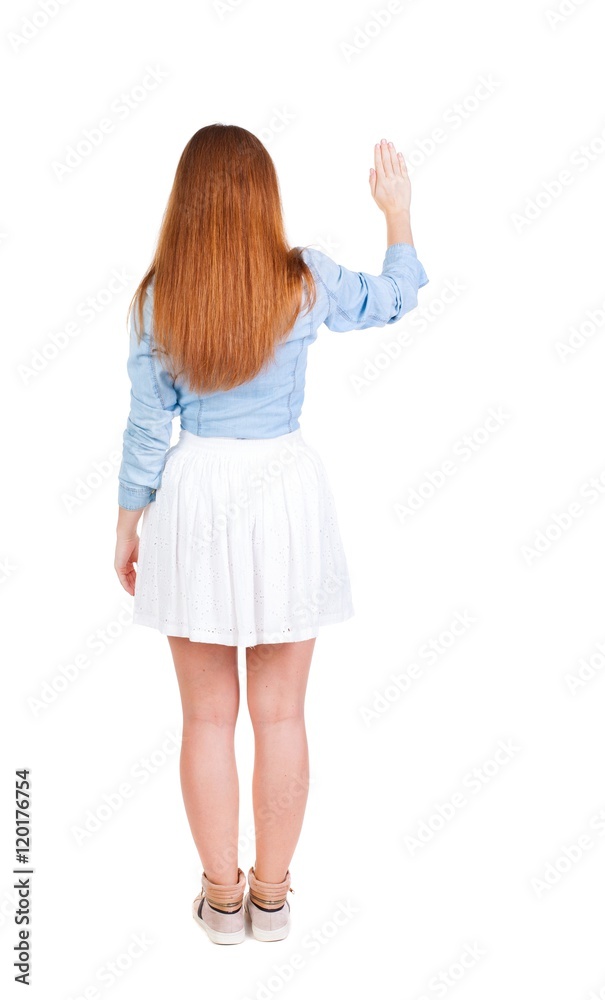 back view of woman. Young woman in dress presses down on something. Isolated over white background. Rear view people collection. backside view of person. she holds his hand open, palm forward back view of woman. Young woman in dress presses down on something. Isolated over white background. Rear view people collection. backside view of person. she holds his hand open, palm forward