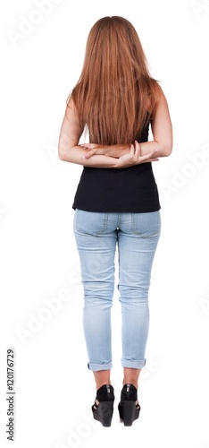 back view of standing beautiful red head woman. Young redhead girl in jeas. Rear view. Isolated over white background photo