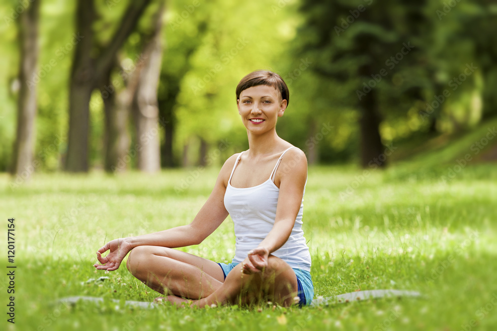 Zen yoga woman lotos position on the grass.