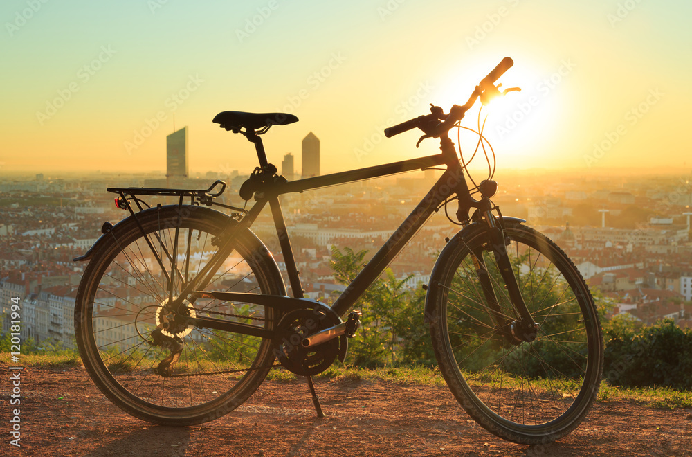 Fototapeta premium Urban sports bicyle and a warm sunrise over Lyon, France.