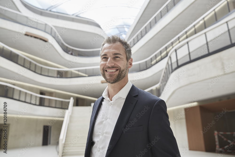 Smiling businessman in office building Smiling businessman in office building