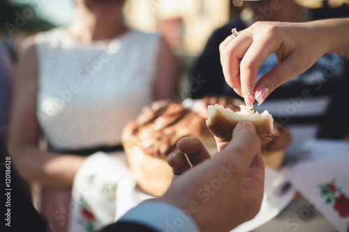 Groom and bride are trying a wedding bread
