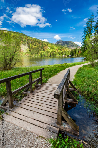 Beautiful small bridge on the lake in the Alps