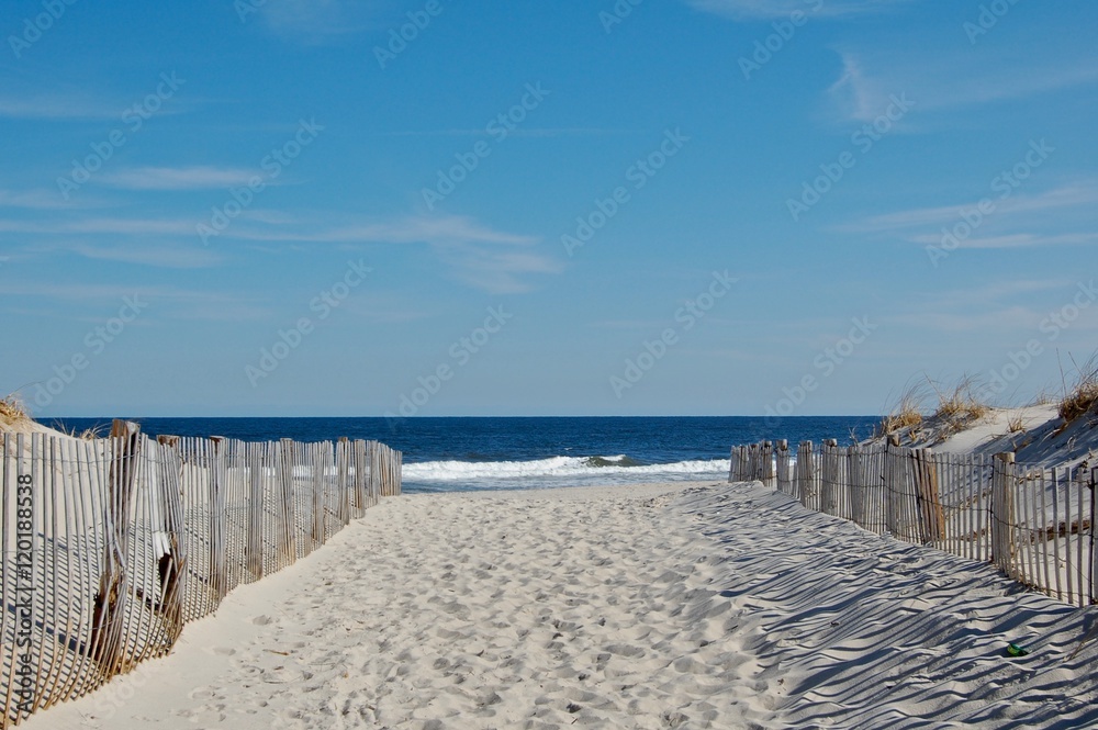 Sunny beach day, waves crashing and blue skies Sunny beach day, waves crashing and blue skies