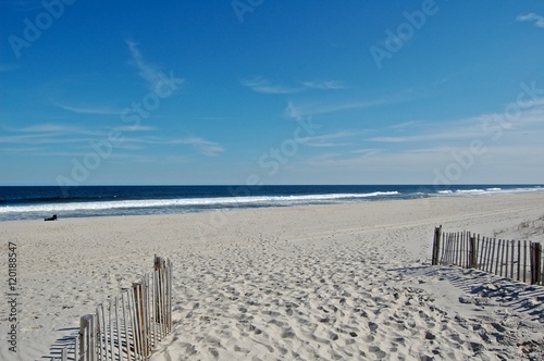 Sunny beach day, waves crashing and blue skies 