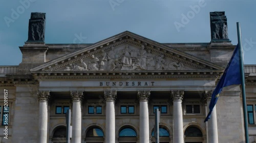 Real time locked down shot of Bundesrat building front facade in Berlin, Germany. EU flag is waving on the wind in front of Bundesrat. Medium shot. photo