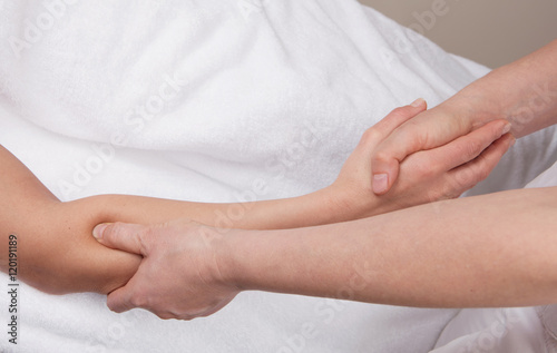 A therapist doing deep tissue recovery massage on a woman's fore