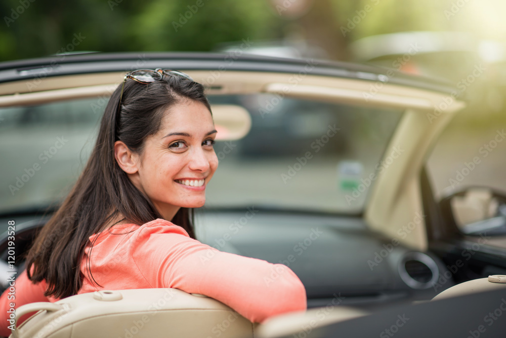  A beautiful young woman driving her convertible car