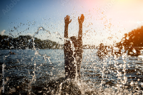 little kid play in water and making splash;