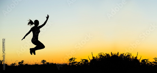 Happiness - happy jumping female silhouette at sunset