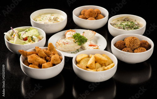 Mixed brazilian snacks, including pastries, fried chicken, salad