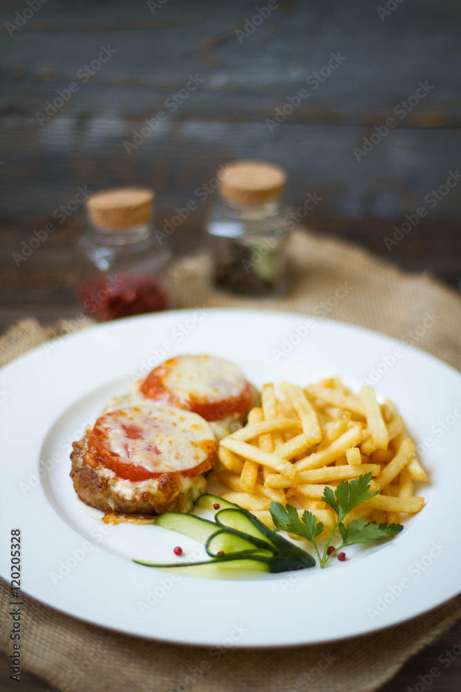 Meat baked with cheese and tomato served with fries Meat baked with cheese and tomato served with fries