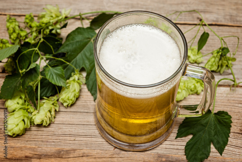 Mug of   beer and hop cones on wooden table