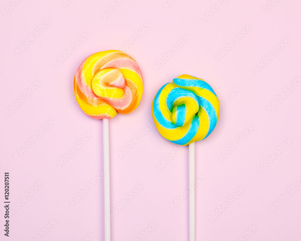 Flat lay. Two colorful lollipops on a pink background Flat lay. Two colorful lollipops on a pink background
