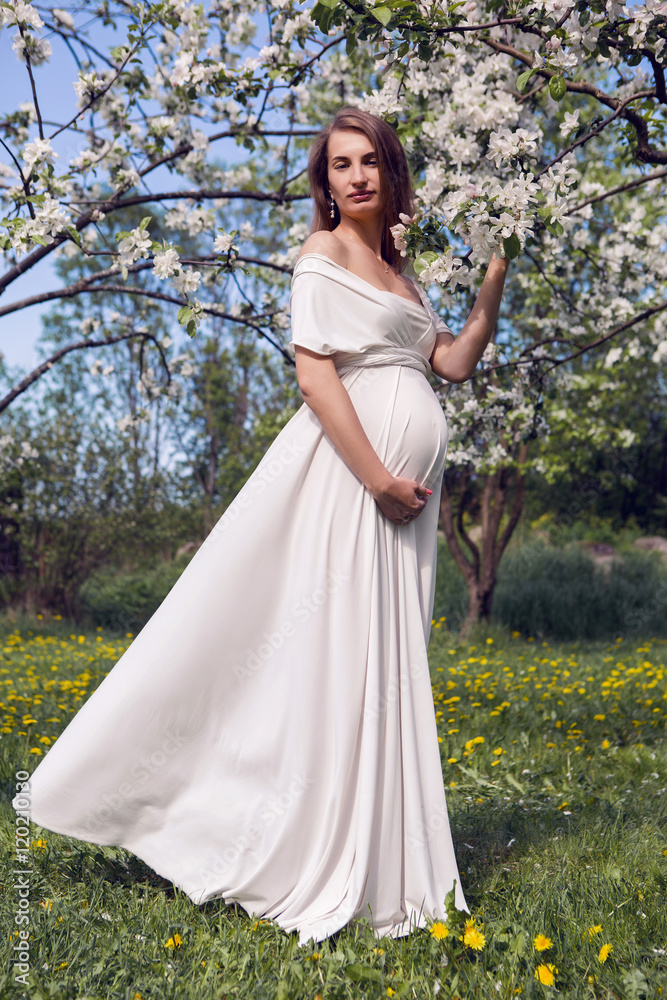 pregnant girl with long hair wearing a white dress standing pregnant girl with long hair wearing a white dress standing