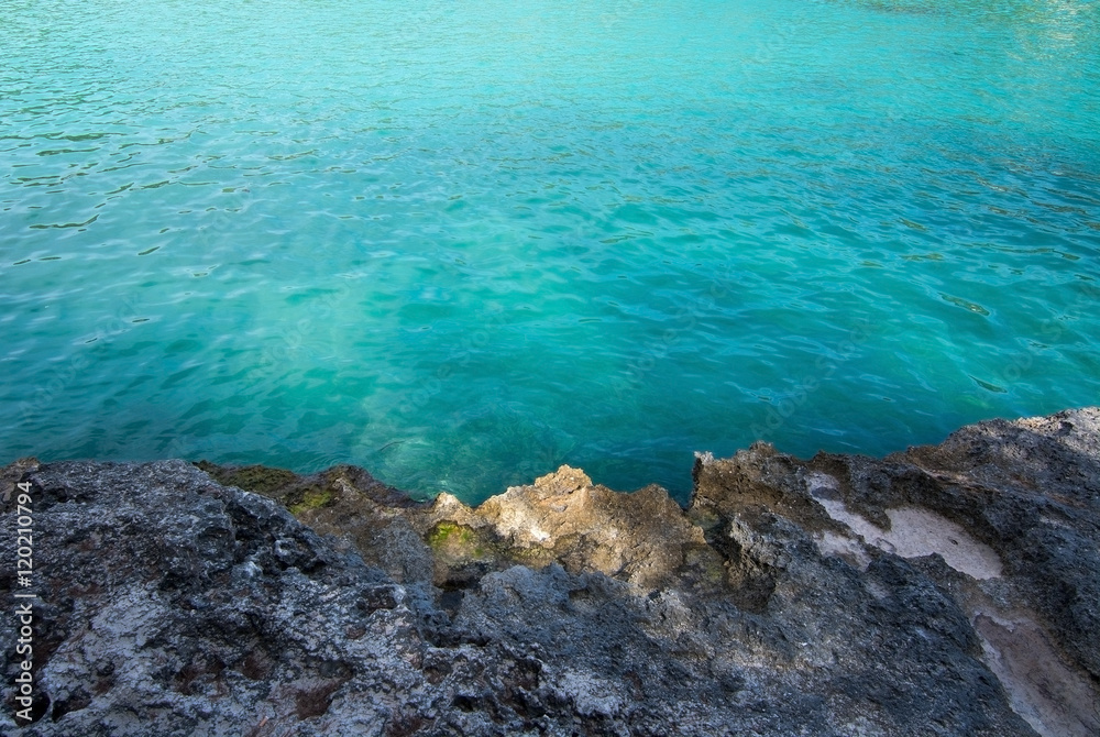 Rock and clear turquoise water background
