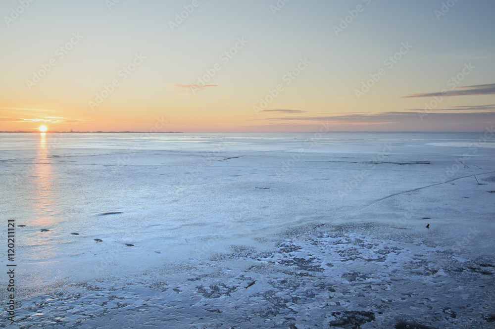 cold landscape on a frozen lake at sunset