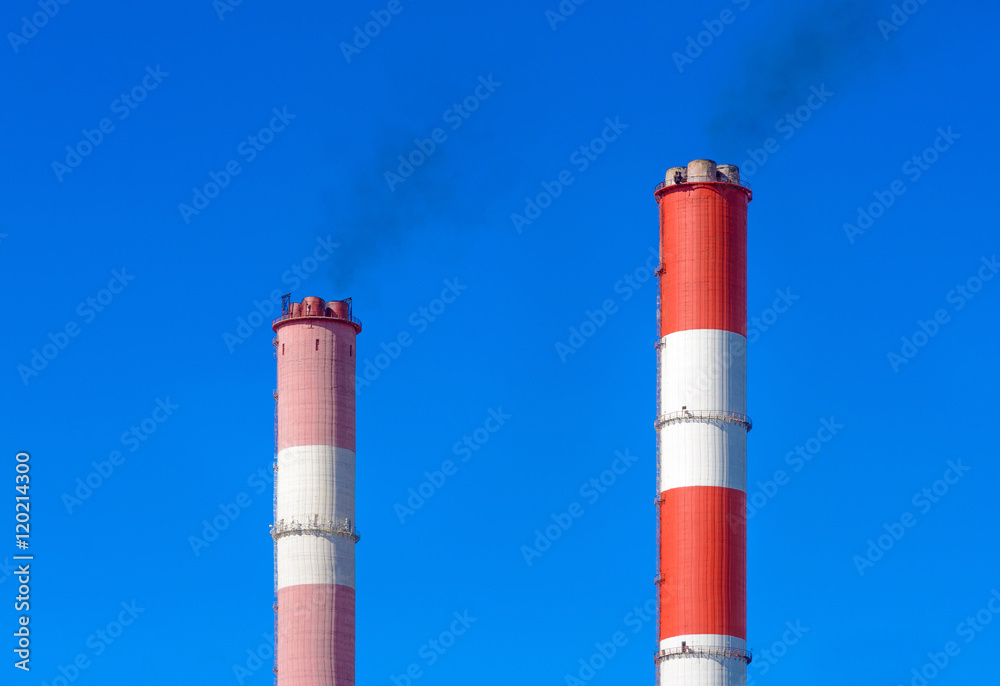 Smoking pipes of thermal power plant against blue sky Smoking pipes of thermal power plant against blue sky
