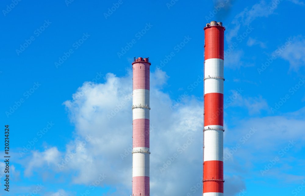 The smoke from the chimneys against the blue sky with clouds The smoke from the chimneys against the blue sky with clouds