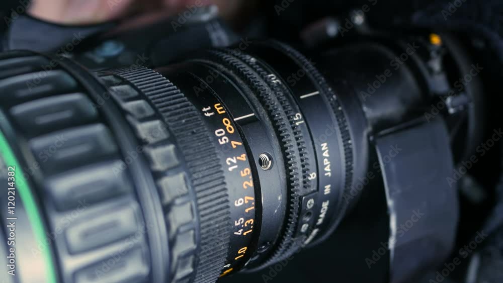 Studio camera. Cameraman changing camera settings focal length, aperture and zoom preparing for shooting. 4K.