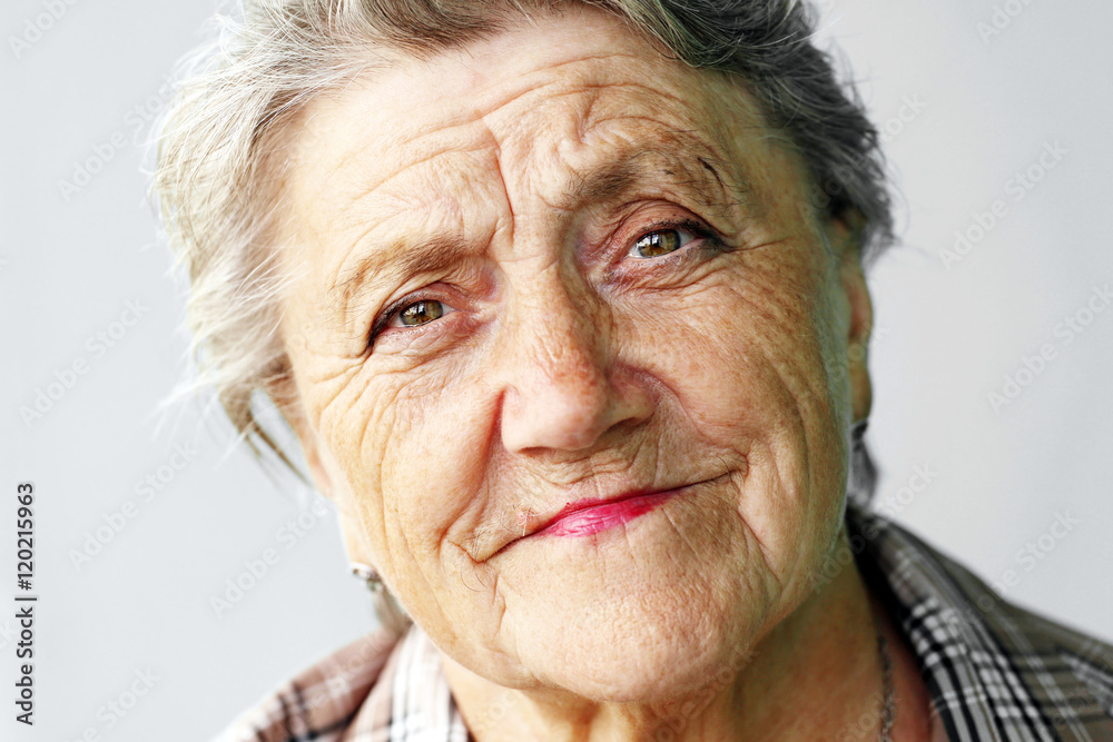 Looking old woman portrait on a grey background Looking old woman portrait on a grey background