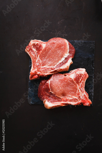 Pork chops on a black table. Raw meat pork.