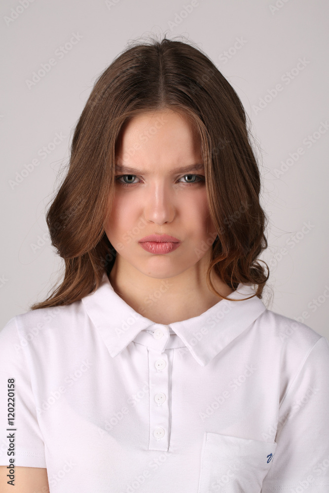 Seious girl in T-shirt. Close up. White background Seious girl in T-shirt. Close up. White background