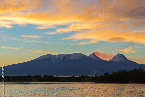 Beautiful sunrise over volcanoes Kluchevskaya group with reflection in the river Kamchatka. photo
