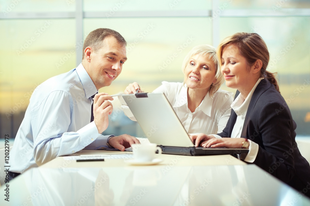 Business people discussing during a meeting and using laptop Business people discussing during a meeting and using laptop