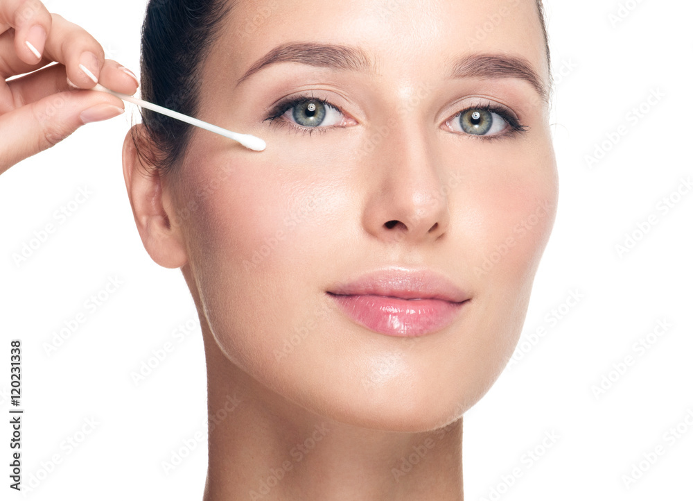 Woman removes makeup from the face with a cotton swab. Happy bea